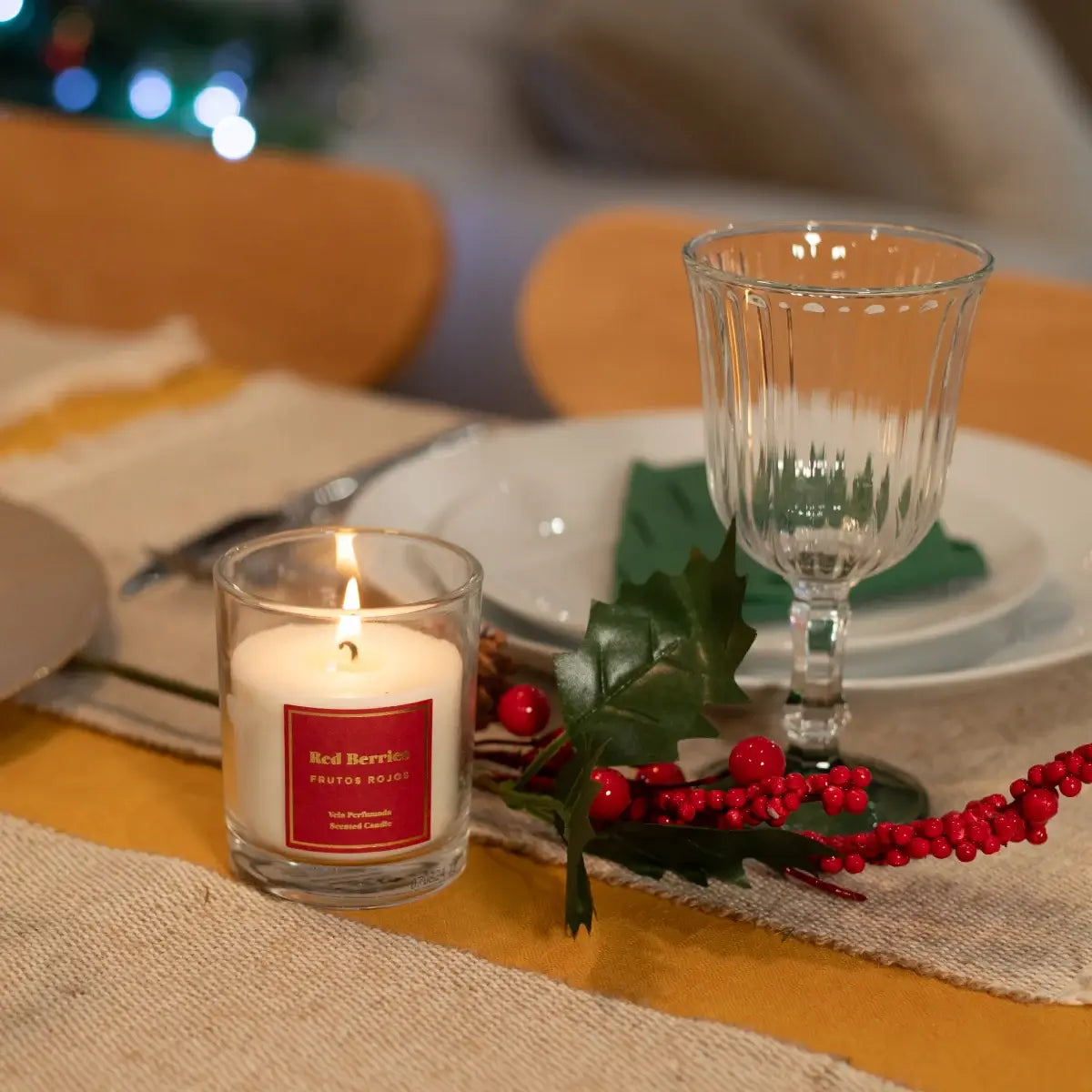 Vela perfumada navideña con frutos rojos.